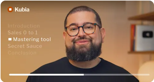 Bearded man with glasses smiling in front of a screen showing Kubia video menu.